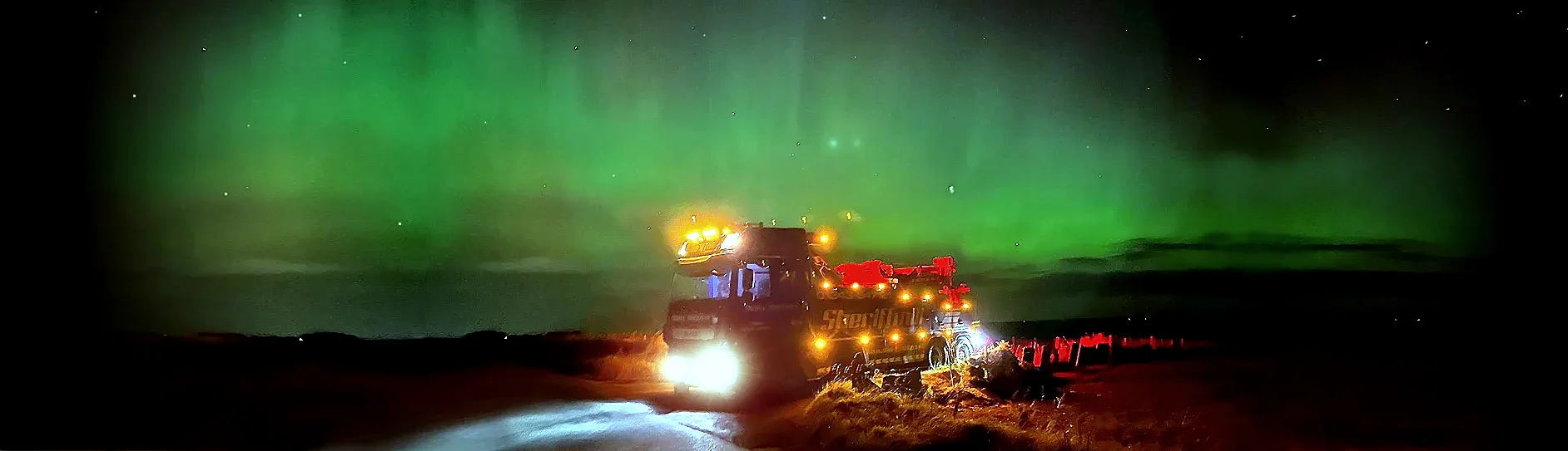 Sheriffmill recovery truck at night under the northern lights